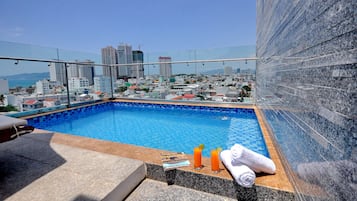 Een buitenzwembad en ligstoelen