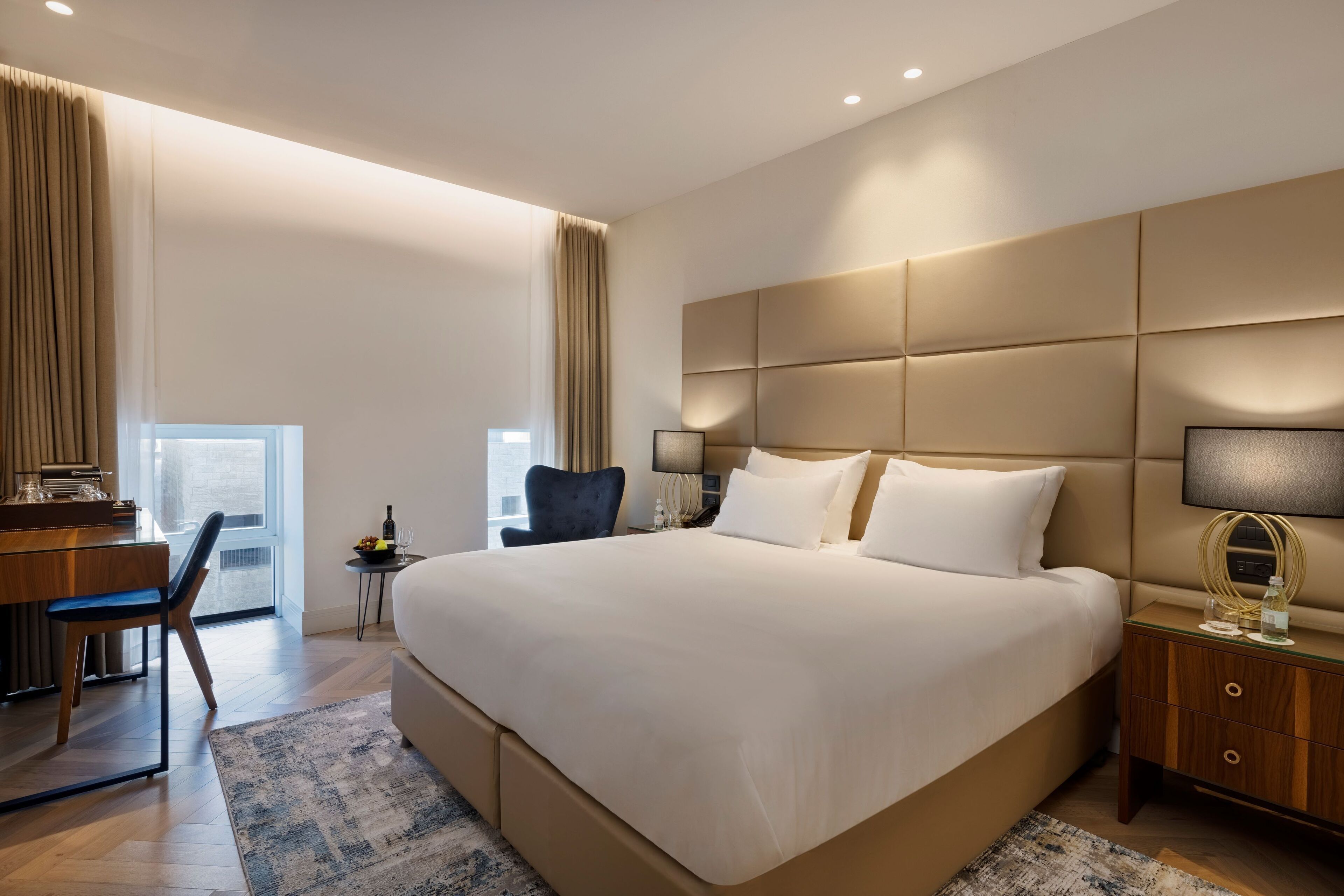Una habitación de hotel moderna con una cama grande, un escritorio y una silla.