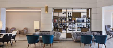 A modern lobby with a seating area, a bookshelf, and a decorative wall.
