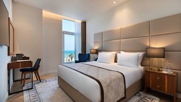 Una habitación de hotel moderna con una cama grande, un escritorio y vistas al océano.