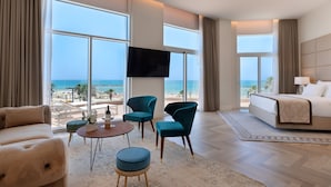 A hotel room with a large window, a bed, a TV, and a seating area with a table and chairs. - Herbert Samuel Opera Tel Aviv (Tel Aviv)
