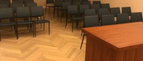 A conference room with a wooden table and rows of chairs.