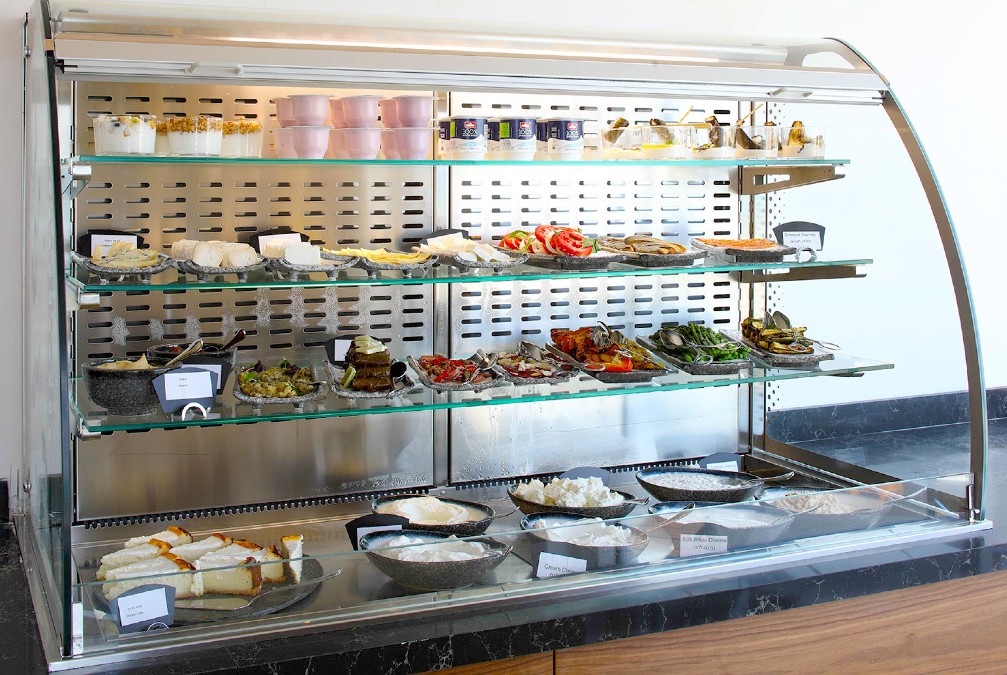 Un buffet con diversi cibi e contenitori disposti su più ripiani.