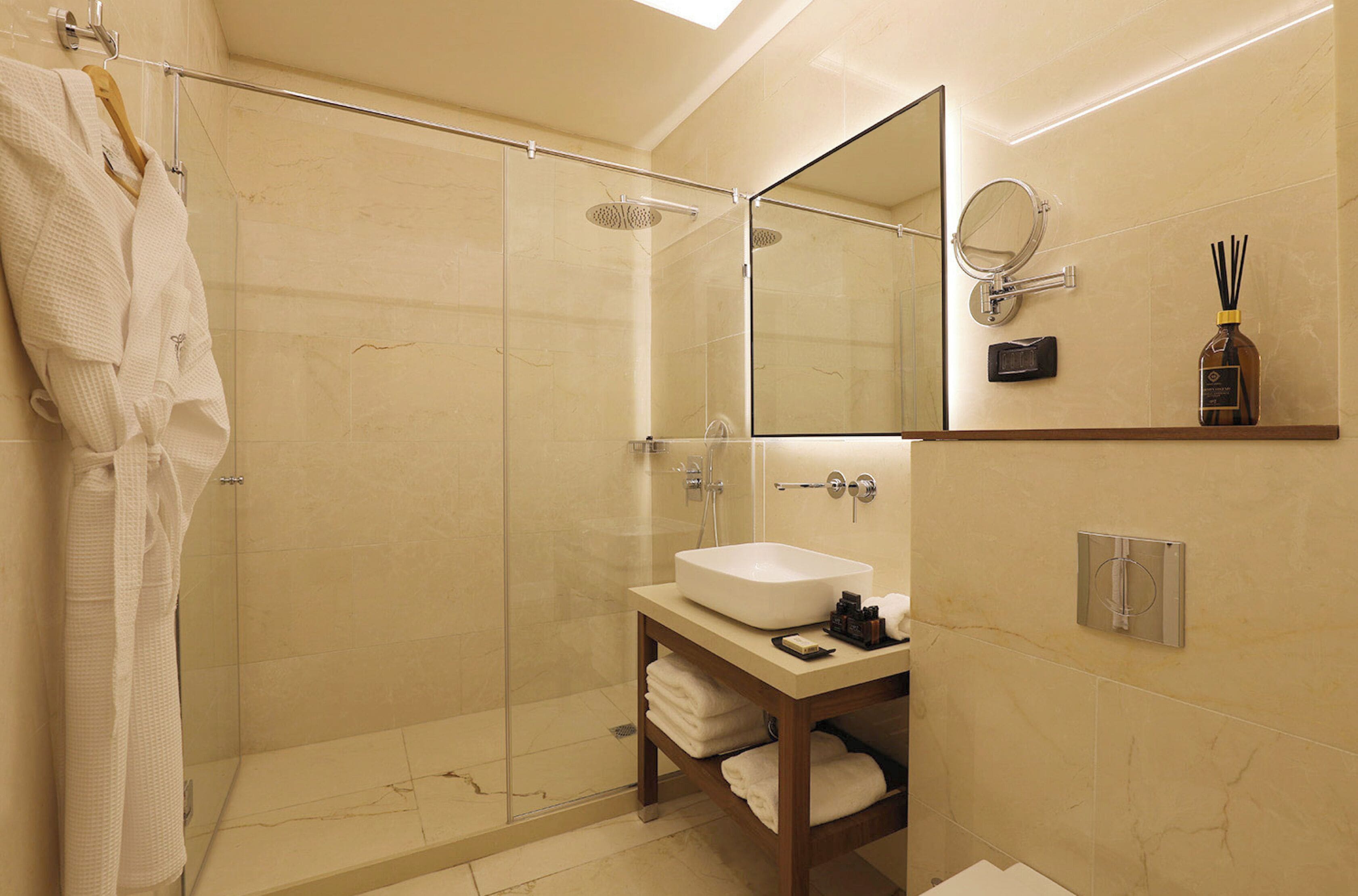 A modern bathroom with a glass-enclosed shower, a vanity with a sink, and a mirror above it.