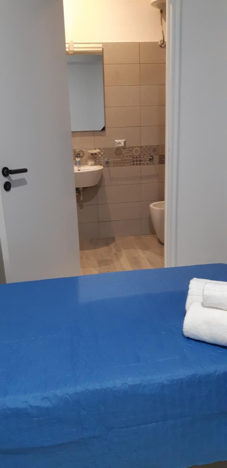 Een badkamer met een wastafel, toilet en spiegel.