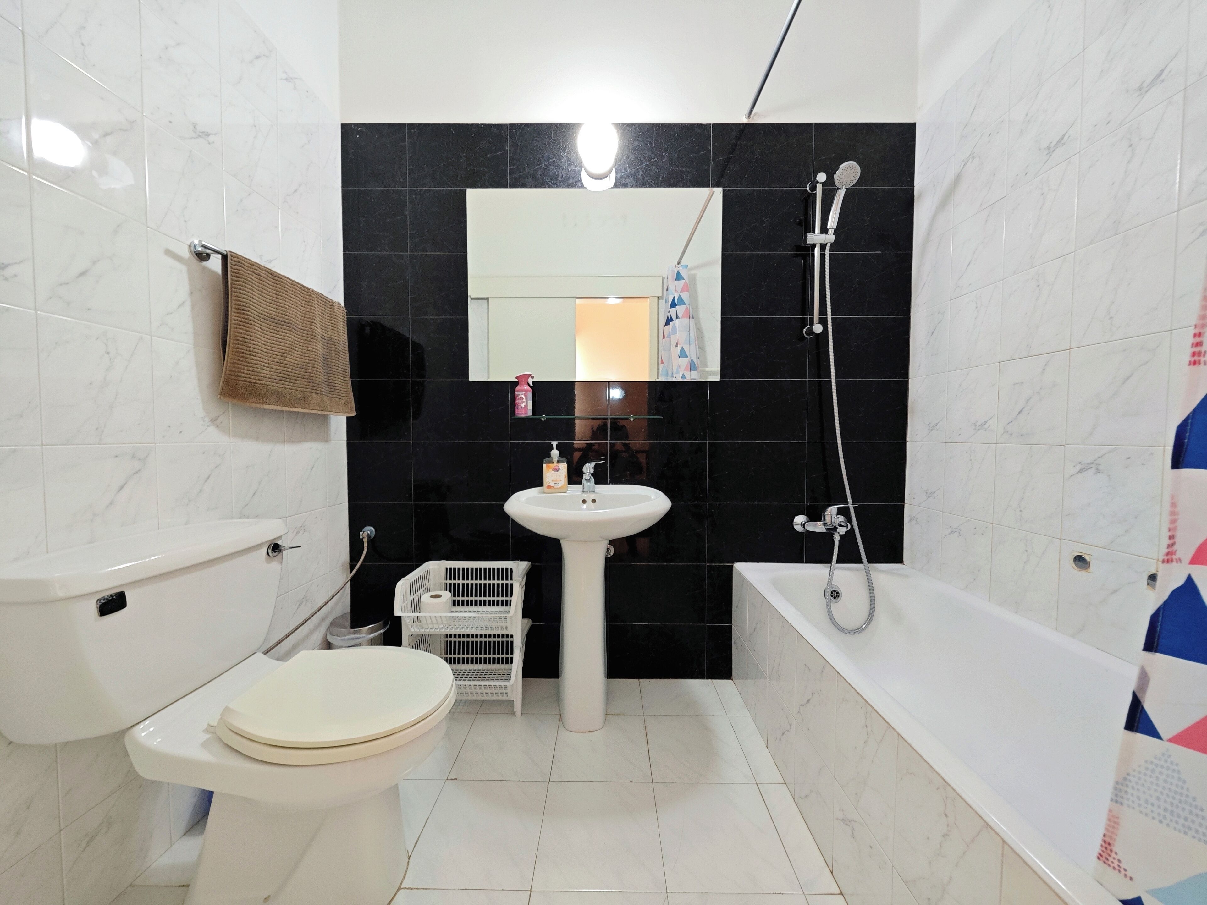 A bathroom with a toilet, sink, and bathtub.