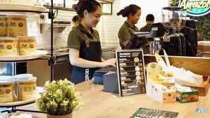 A coffee shop counter with a menu board, a selection of pastries, and a display of coffee beans. - B Stay Hotel (Bangkok)