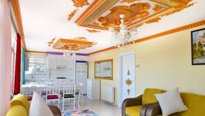 A living room with a yellow sofa, a white couch, and a dining area with a white table and chairs. - Seaside House (Ordu)