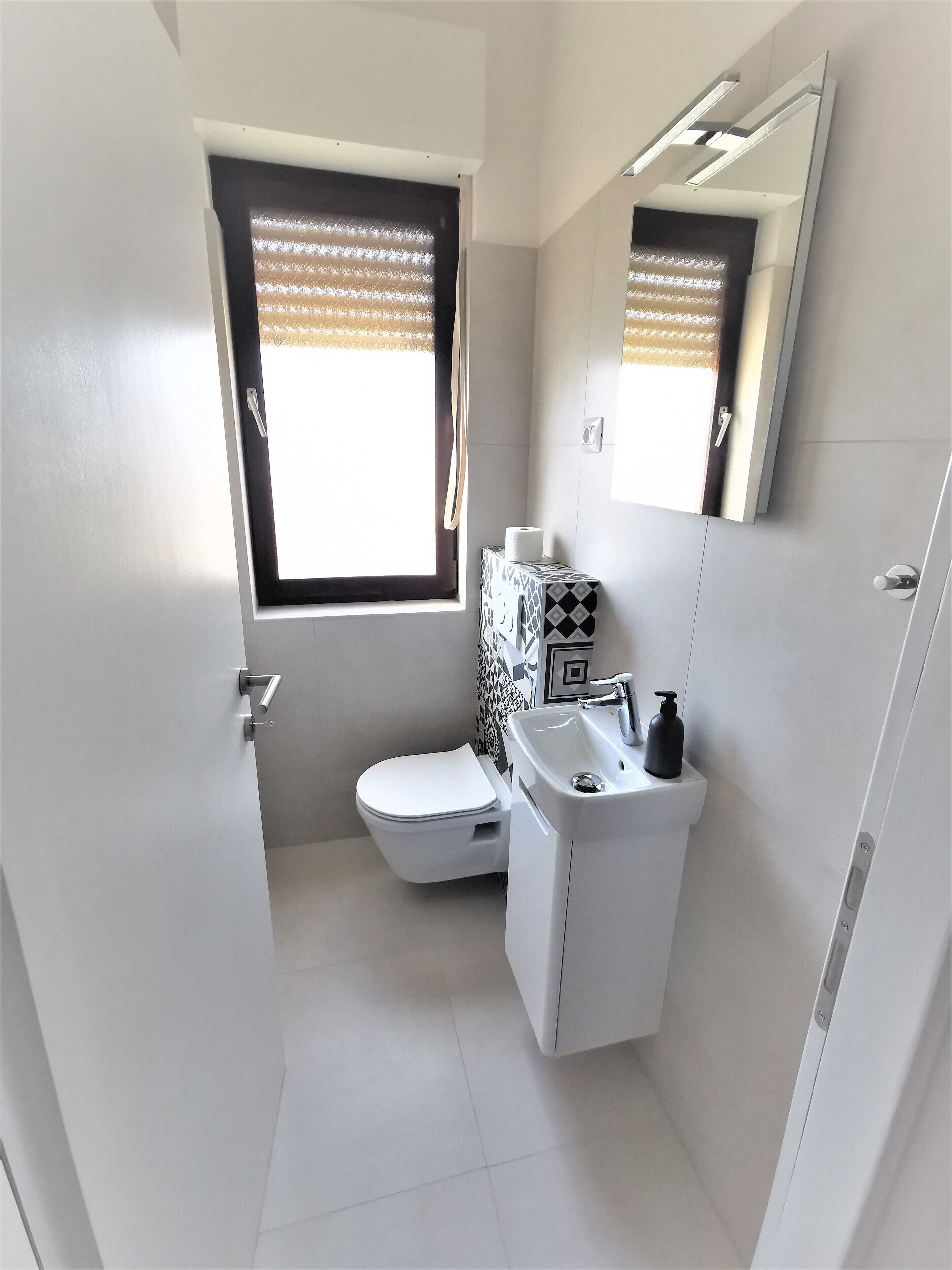 Une salle de bain moderne avec des toilettes, un lavabo et un miroir.