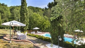 A backyard with a swimming pool, patio furniture, and a brick pathway. - 4 bed apartment with pool (Pontremoli)