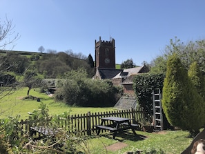 Experience the tranquility of a historic church surrounded by lush greenery and a picturesque landscape.