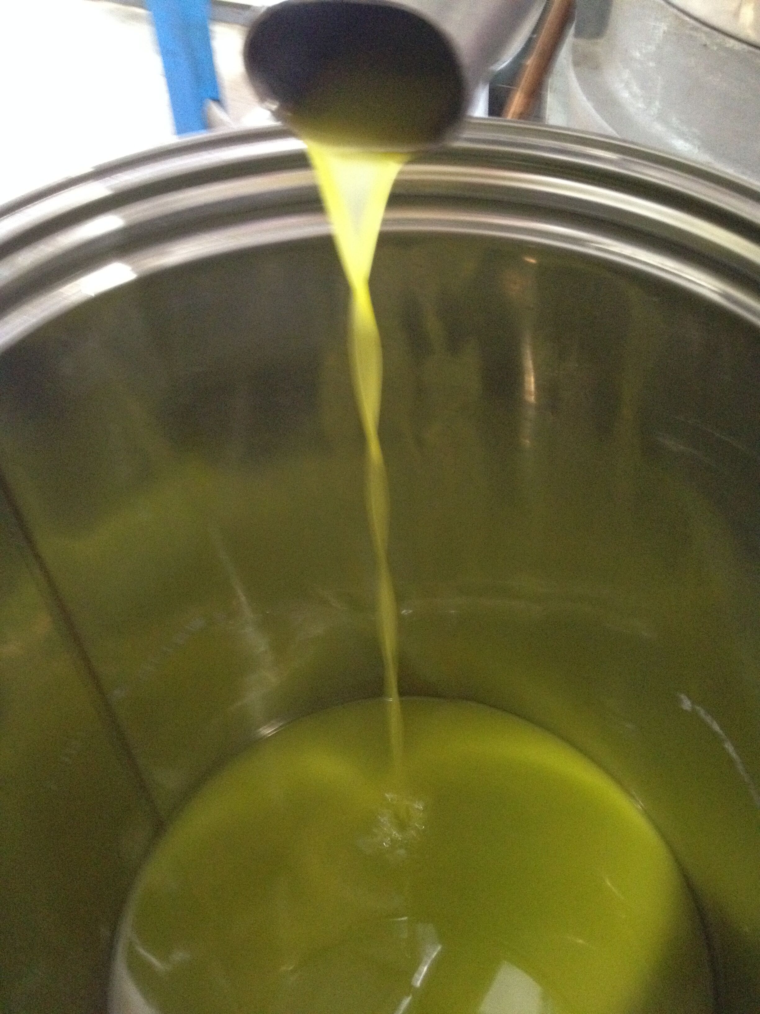 A container with a green liquid being poured into it.