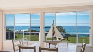 A room with a large window overlooking the ocean, a sailboat model, and a dining table with chairs. - 31 McMillan Crescent, Dalmeny (Dalmeny)