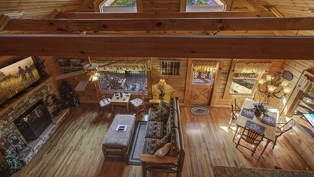 Un interior de cabaña de madera espaciosa con una chimenea acogedora, muebles de madera y un comedor.