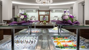 A buffet setup with various food items and a chandelier. - Hotel Nabokov (Marianske Lazne)