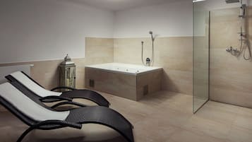 Une salle de bain moderne dotée d’une douche à parois de verre, d’une baignoire sur pieds et de deux fauteuils de relaxation.