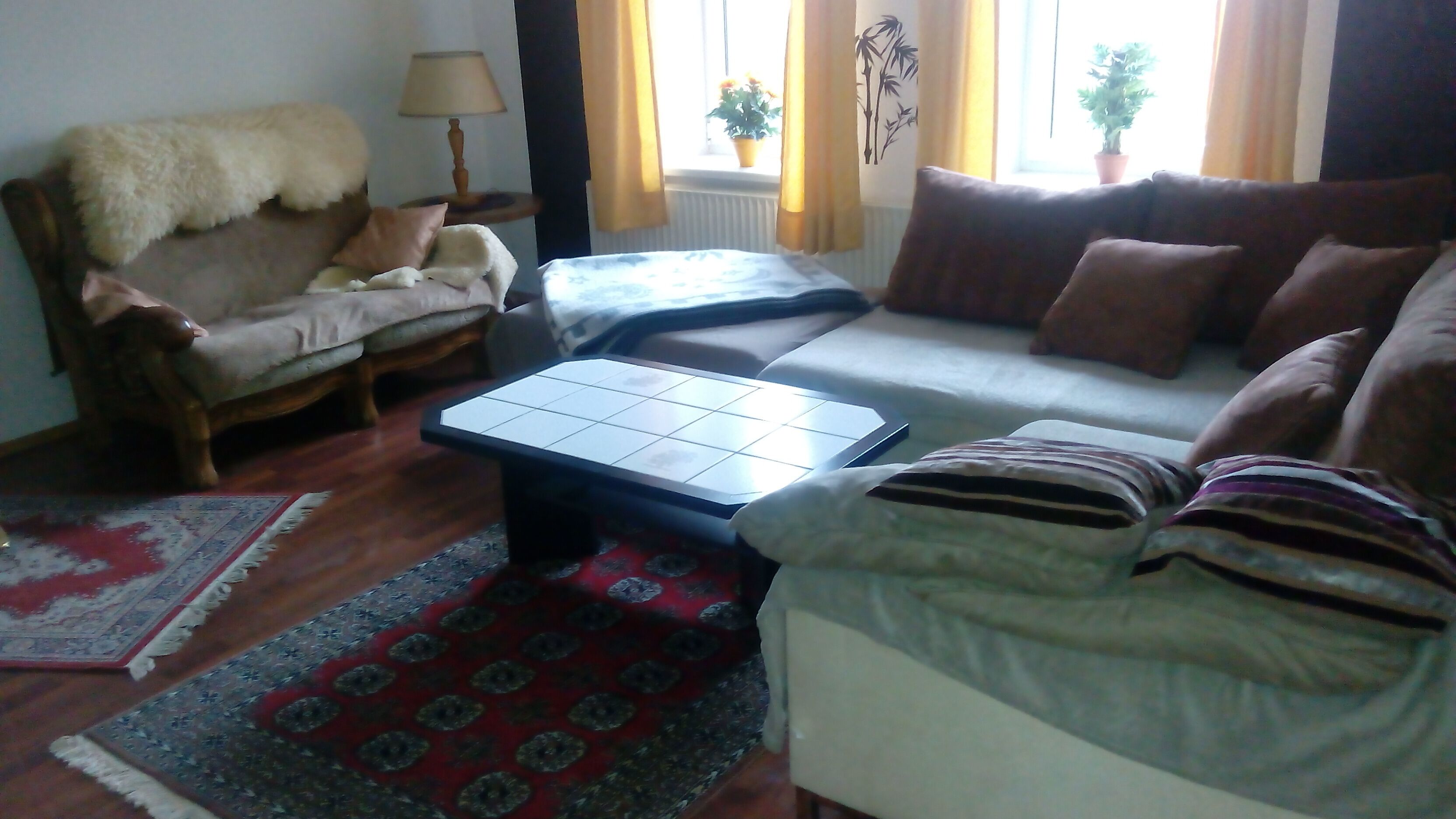 A living room with a sofa, a coffee table, a chair, and a rug.