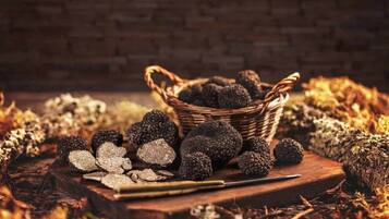 Un panier de truffes noires posé sur une surface en bois, avec un décor rustique en arrière-plan.