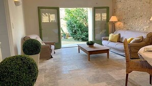 Un salon avec un canapé, une table basse, un fauteuil et une plante en pot.
