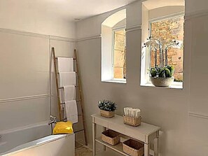 Tina con regadera, secadora de cabello, toallas, papel de baño 