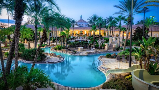 A resort with a central pool, palm trees, and a building with a dome roof. - Sept. Special 6th Night Free in Waterpark Resort & Spa, Golf, minutes to Disney (Davenport)