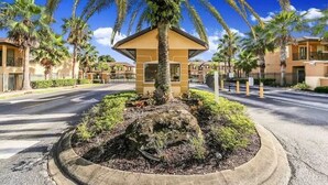 A small, single-story building with a flat roof, surrounded by a landscaped area with palm trees and shrubs. - Sept. Special 6th Night Free in Waterpark Resort & Spa, Golf, minutes to Disney (Davenport)
