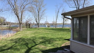 Une terrasse avec vue sur un lac et des arbres.