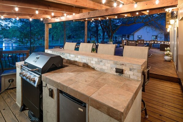 An outdoor kitchen area with a built-in grill and seating.