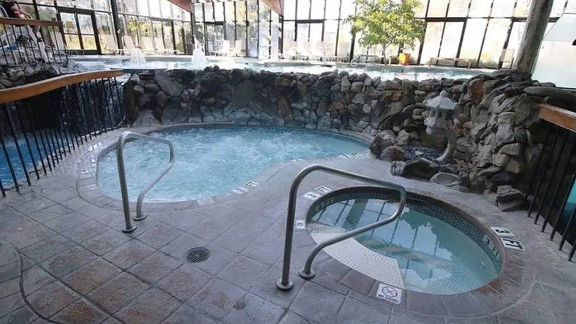 A hot tub area with stone walls and metal railings.