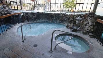 A hot tub area with stone walls and metal railings.