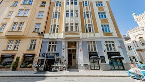 Un edificio a più piani con un ingresso centrale, affiancato da due ristoranti su entrambi i lati.