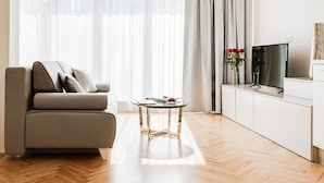 Un soggiorno moderno con un divano, un tavolino, una televisione e un mobile.
