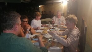 A group of people dining at an outdoor table with various dishes and drinks. - SunTop Inn (Ella)