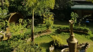 A lush garden with a variety of plants and a decorative fountain. - SunTop Inn (Ella)