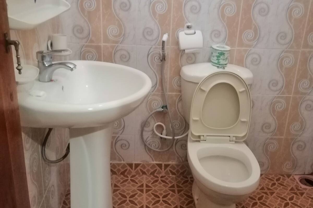 A bathroom with a sink, toilet, and patterned tiles.
