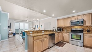 A modern kitchen with granite countertops, stainless steel appliances, and wooden cabinets. - Inn at Crystal Beach 608a * Gulf Front with Beach Chair Set. Onsite dining! (Destin)
