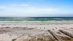 A beach with a wooden boardwalk leading to the shore, sandy dunes, and the ocean. - Inn at Crystal Beach 603b * Gulf Front with Beach Chair Set. Onsite dining! (Destin)