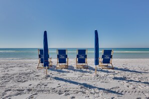Vier strandstoelen met parasols bij Crystal Beach.