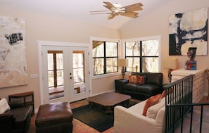 A living room with a fireplace, a sofa, a coffee table, and a staircase.
