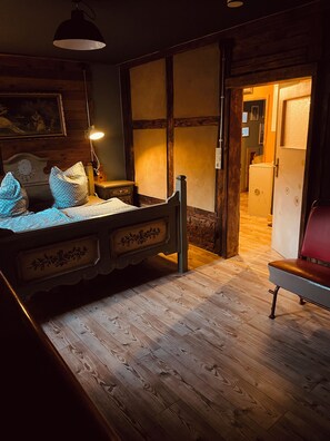 A room with a wooden bed, a nightstand, a lamp, a chair, and a wardrobe. - Apartment Vintage Home 55 (EA)
