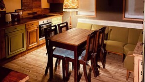 Une cuisine chaleureuse avec des meubles en bois, une table à manger et des chaises.