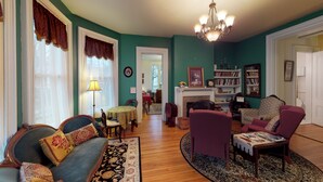 Ein Wohnzimmer mit Kamin, einer Chandelüster und einem Bücherregal.