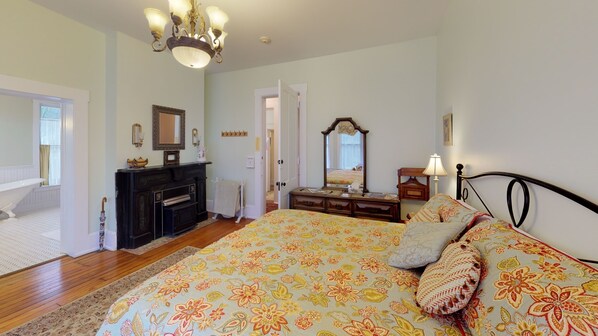 A bedroom with a large bed, a dresser, a mirror, and a chandelier. - Romantic Room, Clawfoot tub in B & B Hocking Hills (Nelsonville)