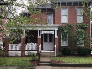 A two-story brick house with a front porch and a sign reading "The Wyde House."