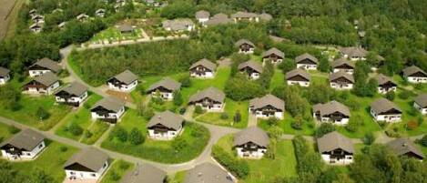 Vista aérea de una zona residencial con casas dispuestas en forma de semicírculo, rodeada de vegetación.