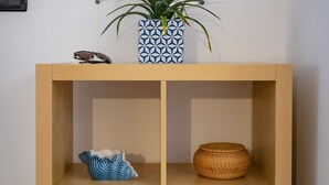 A wooden console with shelves containing decorative items, a framed certificate, and a telephone on the wall. - Casa Zara Sorrento, the perfect apartment to discover the beauties of Sorrento (Sorrento)