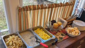 A buffet setup with various food items and utensils.