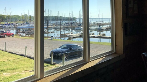 A room with a large window overlooking a marina with boats and a parked car. - Lake Texoma! Beautiful Cabin with Relaxing atmosphere!sleeps 5 (Gordonville)