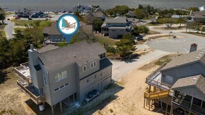 Zona residencial costera con casas, una playa y una extensión de agua.