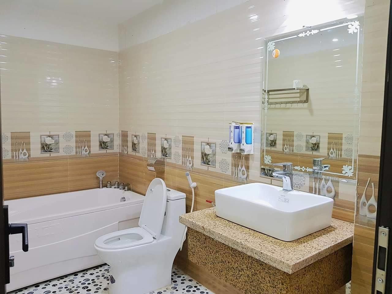A modern bathroom with a bathtub, toilet, and sink.